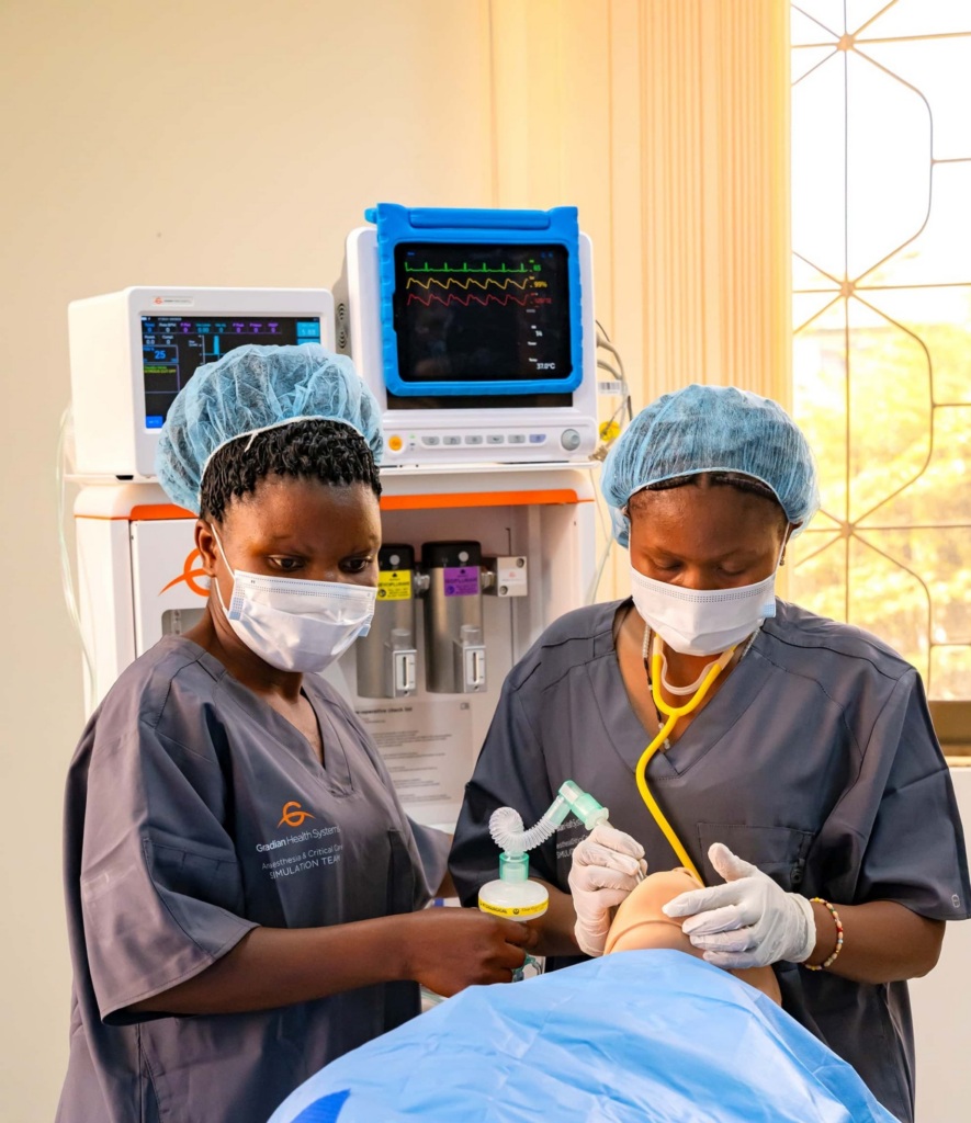 Two women work with a medical mannequin